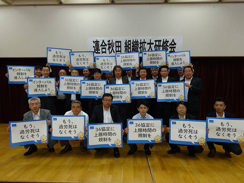 写真:長時間労働是正のボードを掲げる参加者